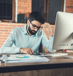 young-businessman-holding-smart-phone-working-office 1