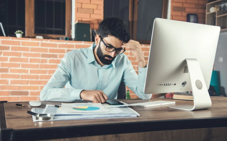 young-businessman-holding-smart-phone-working-office 1