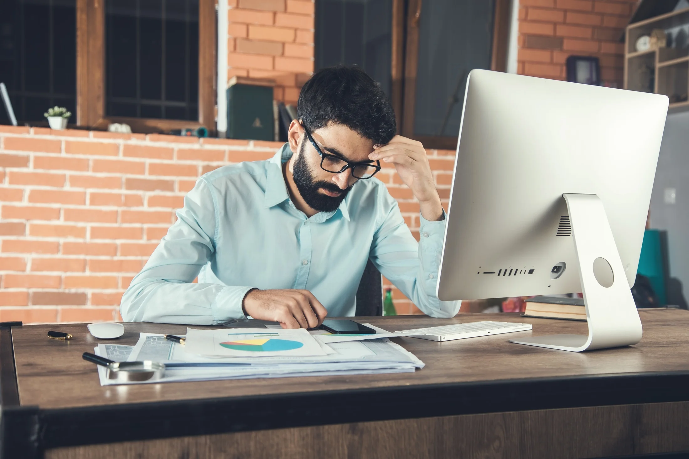 young-businessman-holding-smart-phone-working-office 1